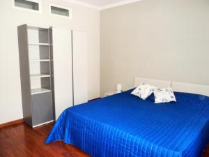 una camera con letto blu e 2 cuscini di VIA PERTINACE 1 - APPARTAMENTO ad Alba