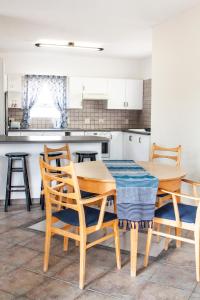 una cucina con tavolo e sedie in legno in una stanza di Swakop Strand Cottage Unit C a Swakopmund