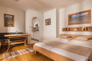 ブルック・アン・デア・グロースグロックナーシュトラーセにあるFerienwohnung Salzburgのベッドルーム1室(ベッド1台、テーブル、デスク付)
