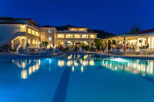 a large swimming pool in front of a building at night at Klelia Beach Hotel by Zante Plaza in Kalamaki