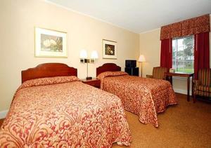una camera d'albergo con due letti e una finestra di Ambassador Inn a Fayetteville