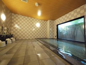 a swimming pool with a large tv in a room at Hotel Route-Inn Suzuka in Suzuka