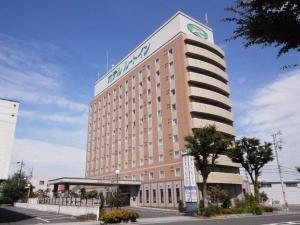 Un gran edificio con un reloj encima. en Hotel Route-Inn Suzuka, en Suzuka
