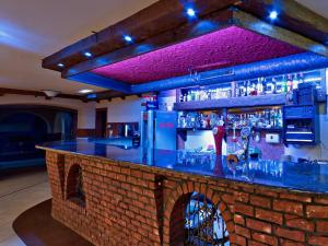 eine Bar mit einer Backsteinwand und einer blauen Bar in der Unterkunft Rota in Biała Podlaska