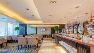 a restaurant with tables and chairs and a bar at Zhejiang Hotel in Hangzhou