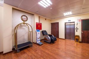 a waiting room with a chair and a clock on the wall at Al Reem Hotel Apartments in Sharjah