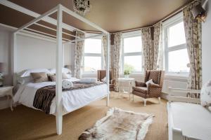 1 dormitorio con cama blanca con dosel y ventanas en Grays Boutique B&B, en Bath