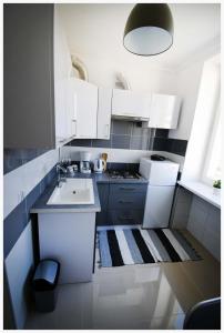 cocina blanca con fregadero y fogones en Color 24 Apartament II, en Stalowa Wola