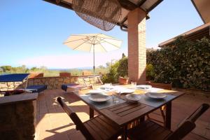 a wooden table with chairs and an umbrella on a patio at CASA MARGOT(RELAX CON VISTA) in Arenella