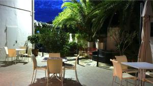 a patio with tables and chairs and tables and trees at Hotel Scigliano in Rossano