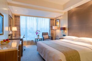 a hotel room with a large bed and a desk at Zhejiang Hotel in Hangzhou