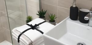 a towel with a black ribbon on a bathroom sink at Apartment Story,Nikole Cupica Beograd in Belgrade +21 photos