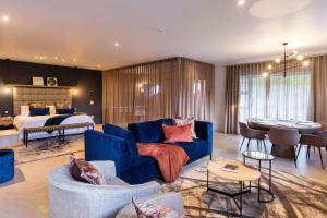 ein Wohnzimmer mit einem blauen Sofa und ein Schlafzimmer in der Unterkunft Nova Boutique Hotel, spa and conference venue in Port Elizabeth