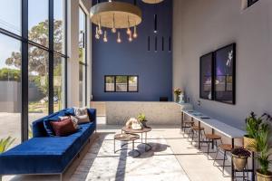 een woonkamer met een blauwe bank en stoelen bij Nova Boutique Hotel, spa and conference venue in Port Elizabeth