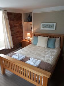 a bedroom with a large bed with towels on it at Halfway House Inn in Kingsand