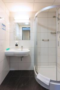 ein Bad mit einem Waschbecken und einer Dusche in der Unterkunft Aqua-Zdrój in Wałbrzych