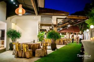 a group of tables with yellow bows on them in a building at Tanjung Villa in Muar