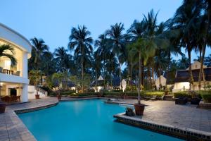 a pool at the resort with palm trees in the background at Aryaduta Lippo Village in Tangerang