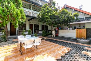 a patio with a table and chairs in front of a building at RedDoorz Plus near Taman Sari 2 in Yogyakarta