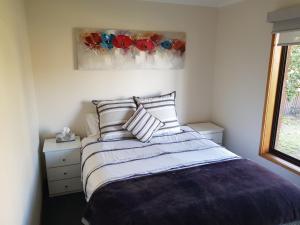 um quarto com uma cama e um quadro de flores em Portarlington beach shack 50 metres to the water em Portarlington