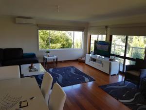 a living room with a couch and a television at Portarlington beach shack 50 metres to the water in Portarlington