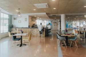 a restaurant with tables and chairs and people in the kitchen at Allegro Murcia Azarbe in Murcia