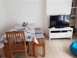 a dining room with a table and a tv at Zeezucht in Koksijde