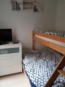 a bedroom with a bunk bed and a desk with a laptop at Zeezucht in Koksijde