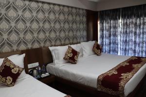 a hotel room with two beds and a window at Hotel Ajmer Tower in Ajmer