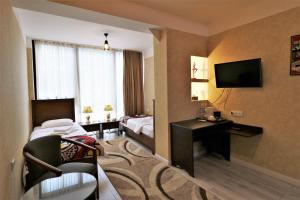 um quarto de hotel com uma cama e uma televisão em Hotel Liberty Theatre em Tbilisi