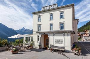 ein Hotelgebäude mit einer Bank davor in der Unterkunft Boutique-Hotel Garni Bellevue Davos Wiesen in Wiesen