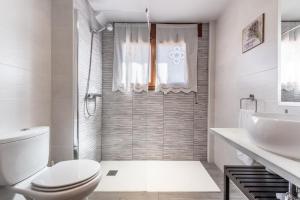 a white bathroom with a toilet and a sink at Apartamento Pirineo Aragonés in Sabiñánigo +47 photos
