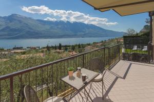 a balcony with a table and chairs and a view of a lake at Villa Imelda, panoramic apartments with Lake Garda views in Limone sul Garda