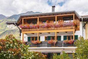 a building with a balcony with flowers on it at Hotel Erna in Colle Isarco