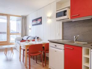 レ・メニュアールにあるtravelski home select - Résidence Les Lysのキッチン、リビングルーム(テーブル、椅子付)