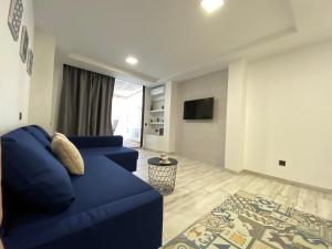 sala de estar con sofá azul y TV en MAGUI´S PLACE en Playa del Ingles