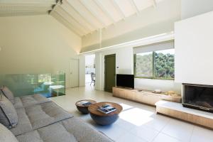 a living room with a couch and a flat screen tv at Physis Villas Chania in Ayiá