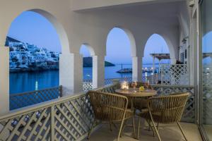 a balcony with a table and chairs with a view of the water at Aphrodite Luxury apartment in Astypalaia