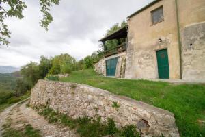 a stone wall next to a building with a green door at Casa dei Templari in Finale Ligure +99 photos