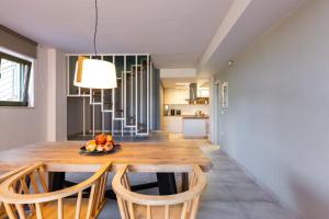 a kitchen and dining room with a wooden table and chairs at Physis Villas Chania in Ayiá
