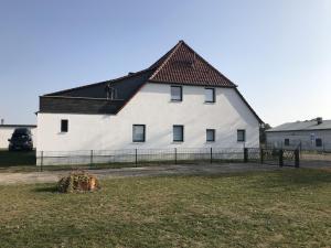 ein großes weißes Gebäude mit schwarzem Dach in der Unterkunft Ferienwohnung Orthsee in Hohen Wangelin