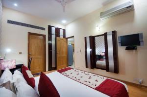 a bedroom with a bed and a flat screen tv at Imperial Apartment Fortis in Gurgaon