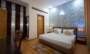 古爾岡的住宿－富通帝國公寓，一间卧室设有一张床和蓝白色的墙壁
