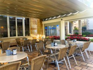 リバデセリャにあるHotel Don Pepeのレストランのパティオ(テーブル、椅子付)