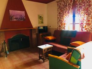 sala de estar con sofá y chimenea en Casa Rural Los Acebos, en Riópar