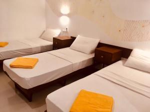 un grupo de 3 camas en una habitación en Visakha 6, en Colombo