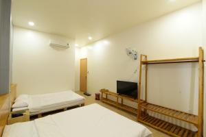 a room with two beds and a flat screen tv at Gấu's House in Vung Tau +7 photos