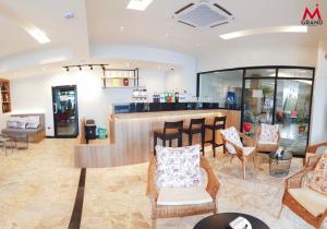 a lobby with a bar with chairs and tables at MGRAND in Roi Et
