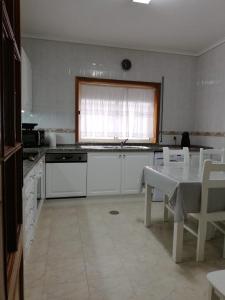 アヴェイロにあるLovely Apartment Aveiroの白いキッチン(テーブル付)