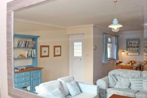 ein Wohnzimmer mit einem Sofa und einem Spiegel in der Unterkunft BY THE BEACH Harlyn Bay in Saint Merryn